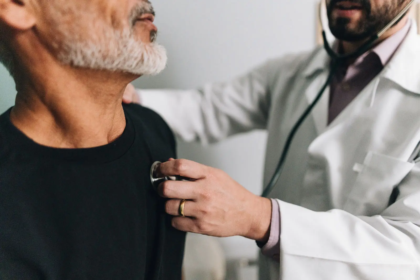 A cardiologist listening to a patient's heart with a stethoscope during an appointment